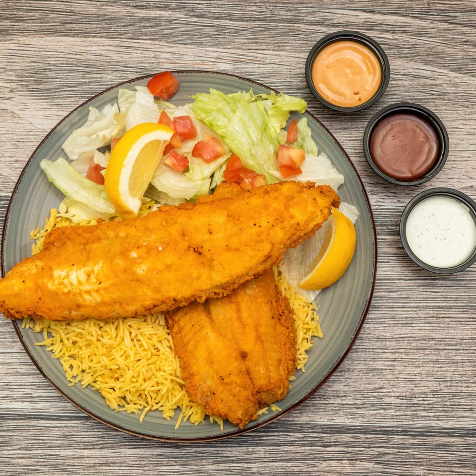 Fish over rice with salad and dipping sauces.